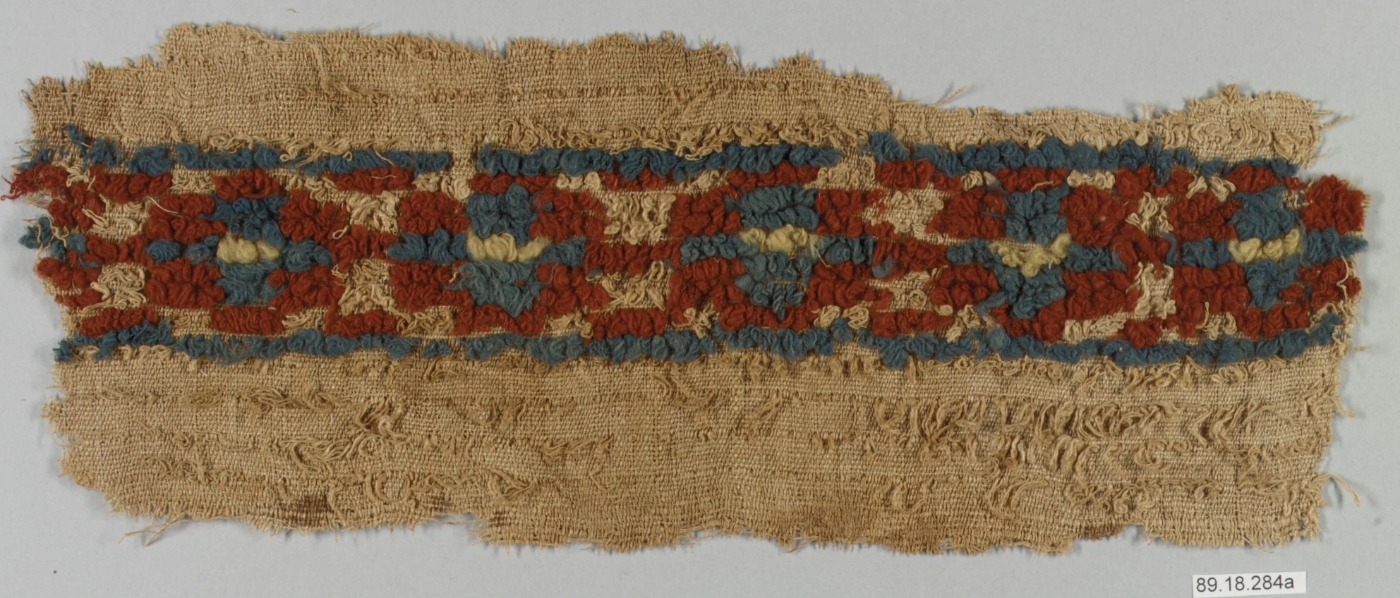 Close view of raised weft loops and woven base in a historical wool-and-linen textile